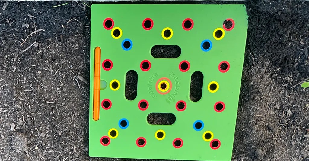 Green Seeding square with many holes at different spacing. Used to help with directly seeding into the garden.
