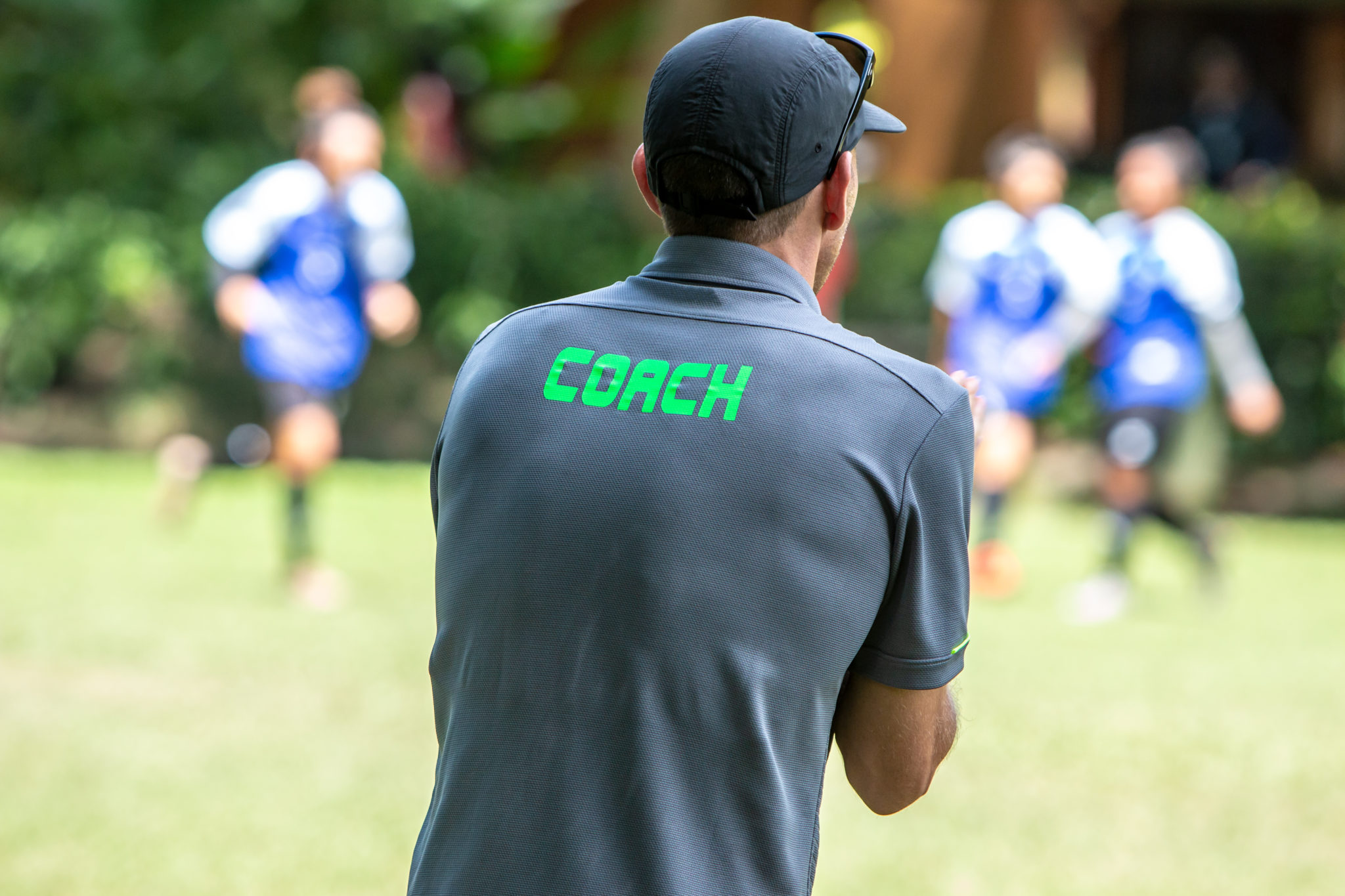 Male soccer or football coach standing on the sideline watching his