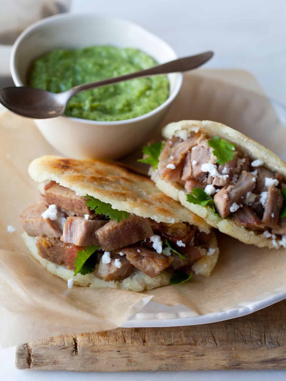 Arepas Filled with Carnitas and Guasacaca Spoon Fork Bacon