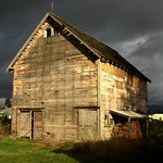 sunlit barn against dark sky