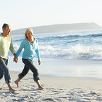 Senior Couple Walking Along Beach