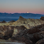 Full Moon setting in alpenglow sky.