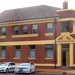 Wellington. NSW. Built as Union Bank in 1921. Note coat of arms in cartouche above doorway on edge of laneway. Note weird shaped balcony above doorway. Terracotta roof tiles. Later ANZ bank till 1900s.