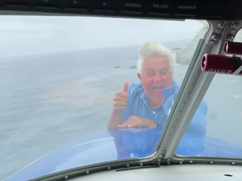 Jay Leno performs surprise midair stunt, dangles out of flying plane