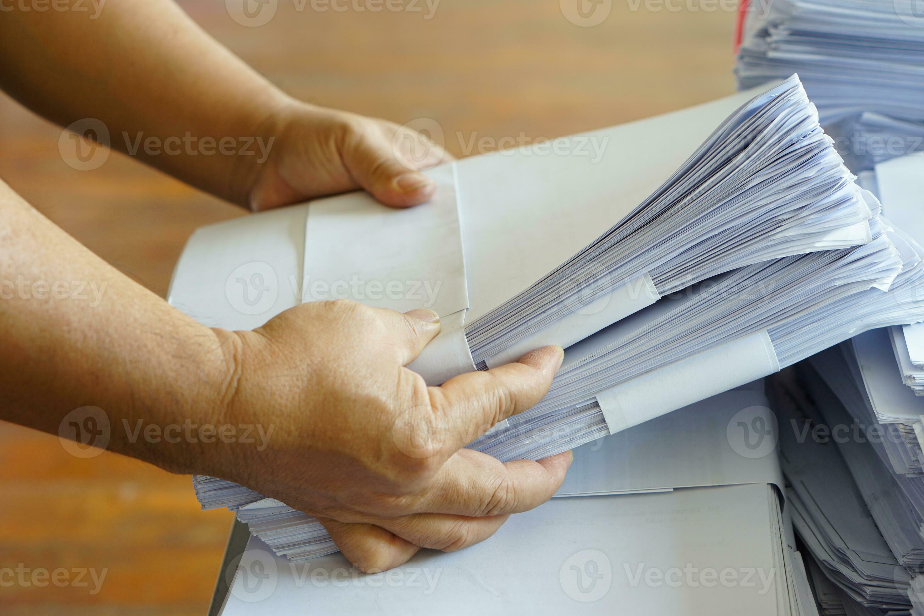 Closeup hands hold stack of used paper to recycle or combine to use