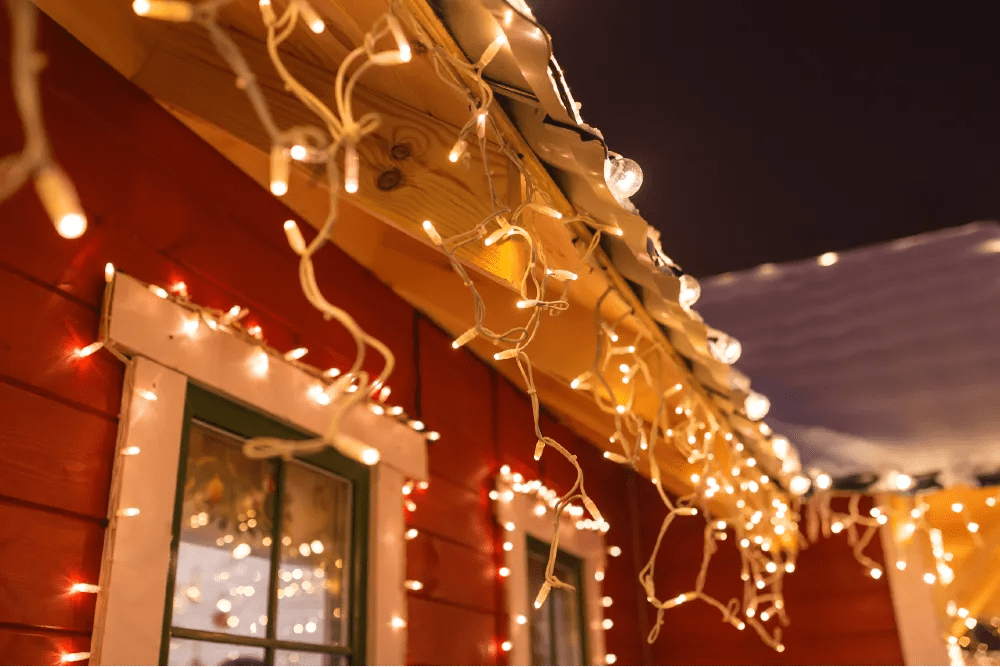 white string lights on exterior of a red home
