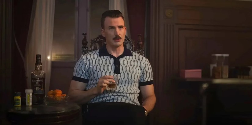 Lloyd Hansen, played by actor Chris Evans, having a drink while sitting on a chair in The Gray Man