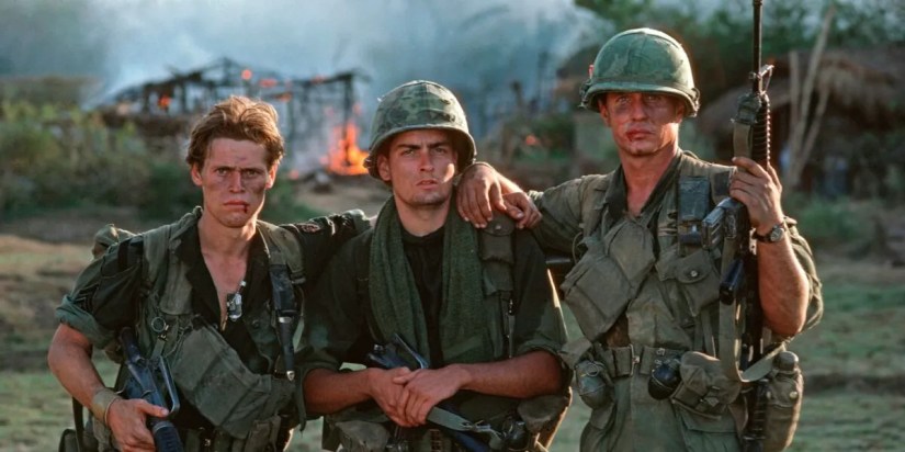 Willem Dafoe, Charlie Sheen, and Tom Berenger in Vietnam War uniforms in the jungle in ‘Platoon’