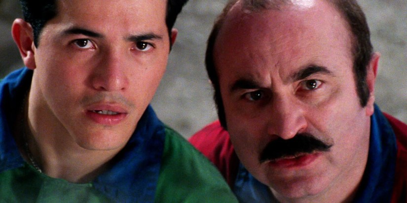 Close up of John Leguizamo as Luigi Mario and Bob Hoskins as Mario Mario looking inquisitive in Super Mario Bros