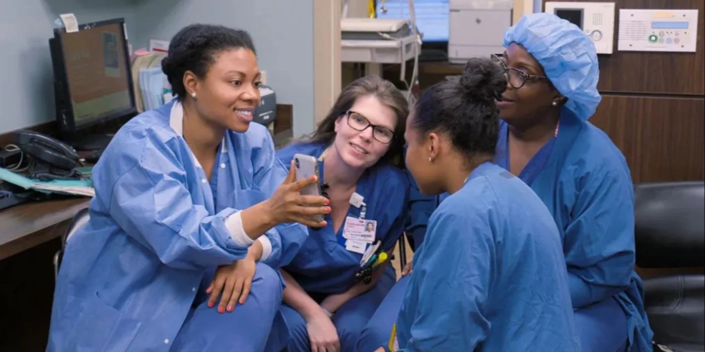 Four doctors looking at a phone and smiling on &lsquo;Lenox Hill&rsquo;