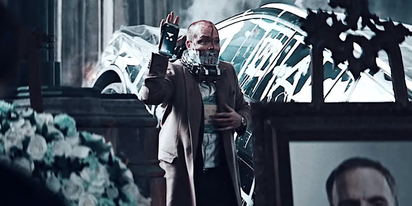 DA holding up phone bomb at the funeral