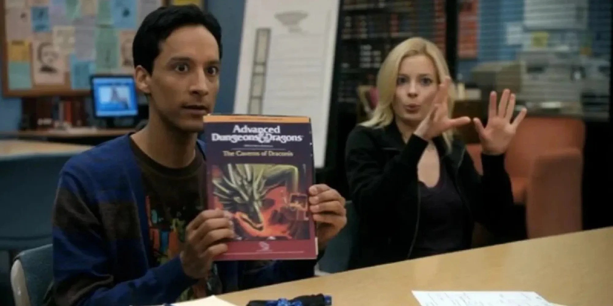 Abed holding up a Dungeons &amp; Dragons book while sitting next to Britta in Community