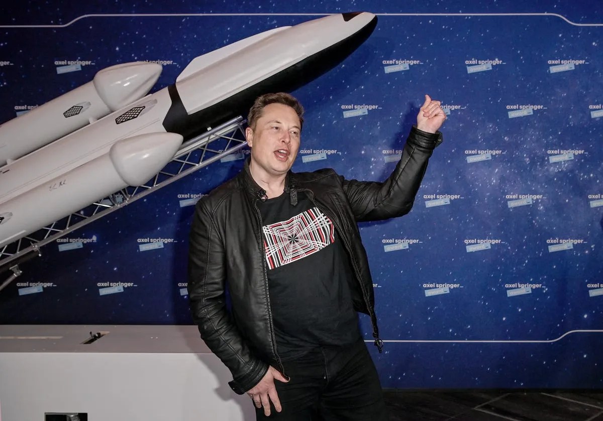 Elon Musk in front of model Starship