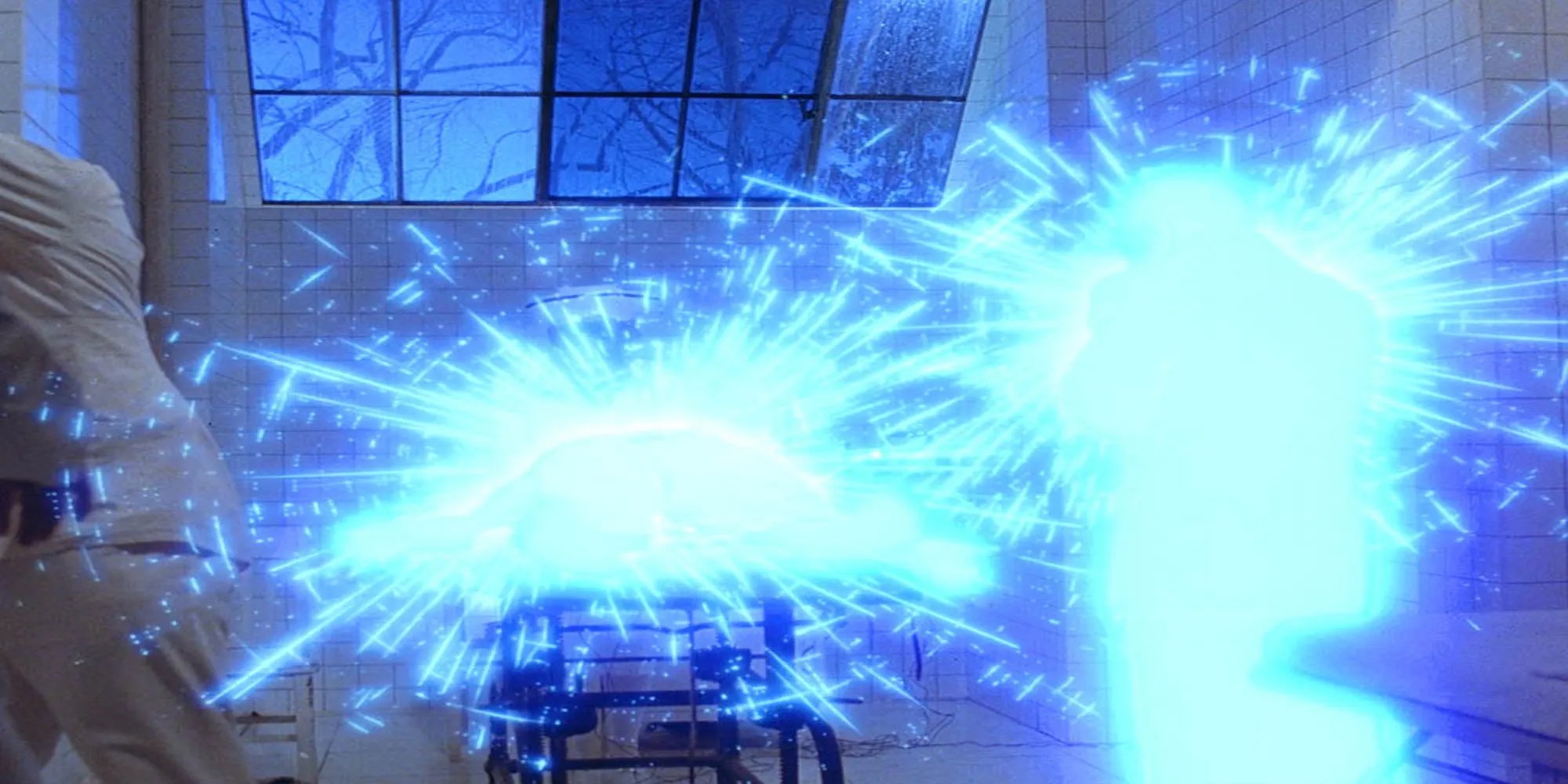 Sam is lying on a hospital bed surrounded by blue light and electricity as he leaps out of a psychiatric hospital