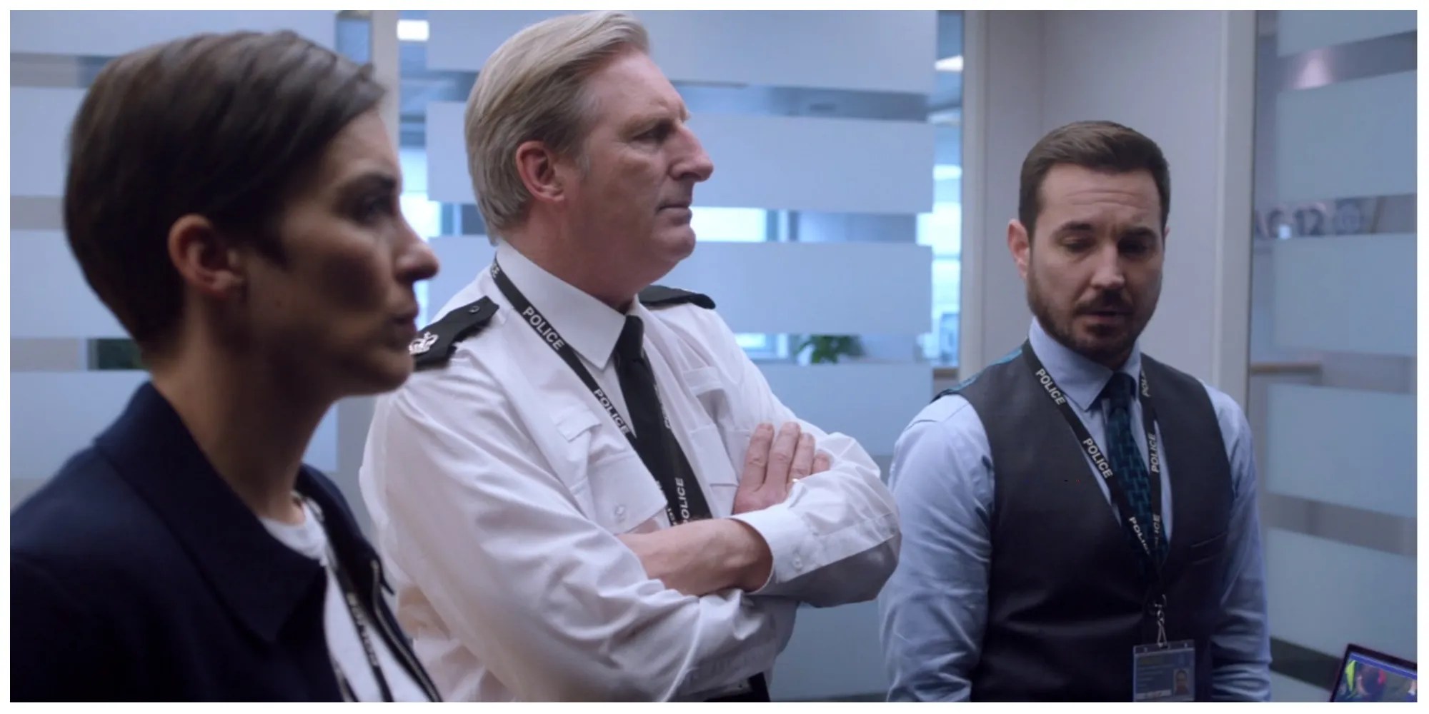 From left to right: police detectives Kate, Ted and Steve stand looking at evidence at work