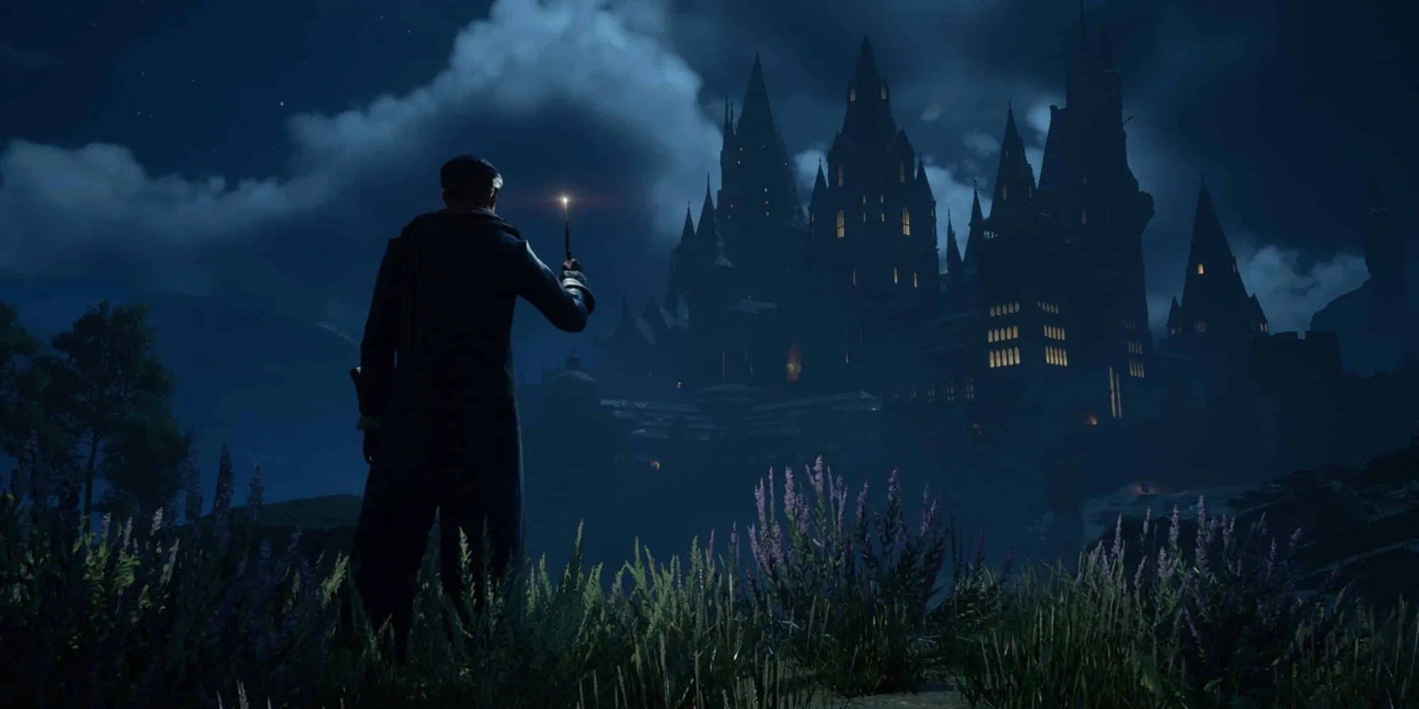 A screenshot of the main character and Hogwarts castle during the night in Hogwarts Legacy