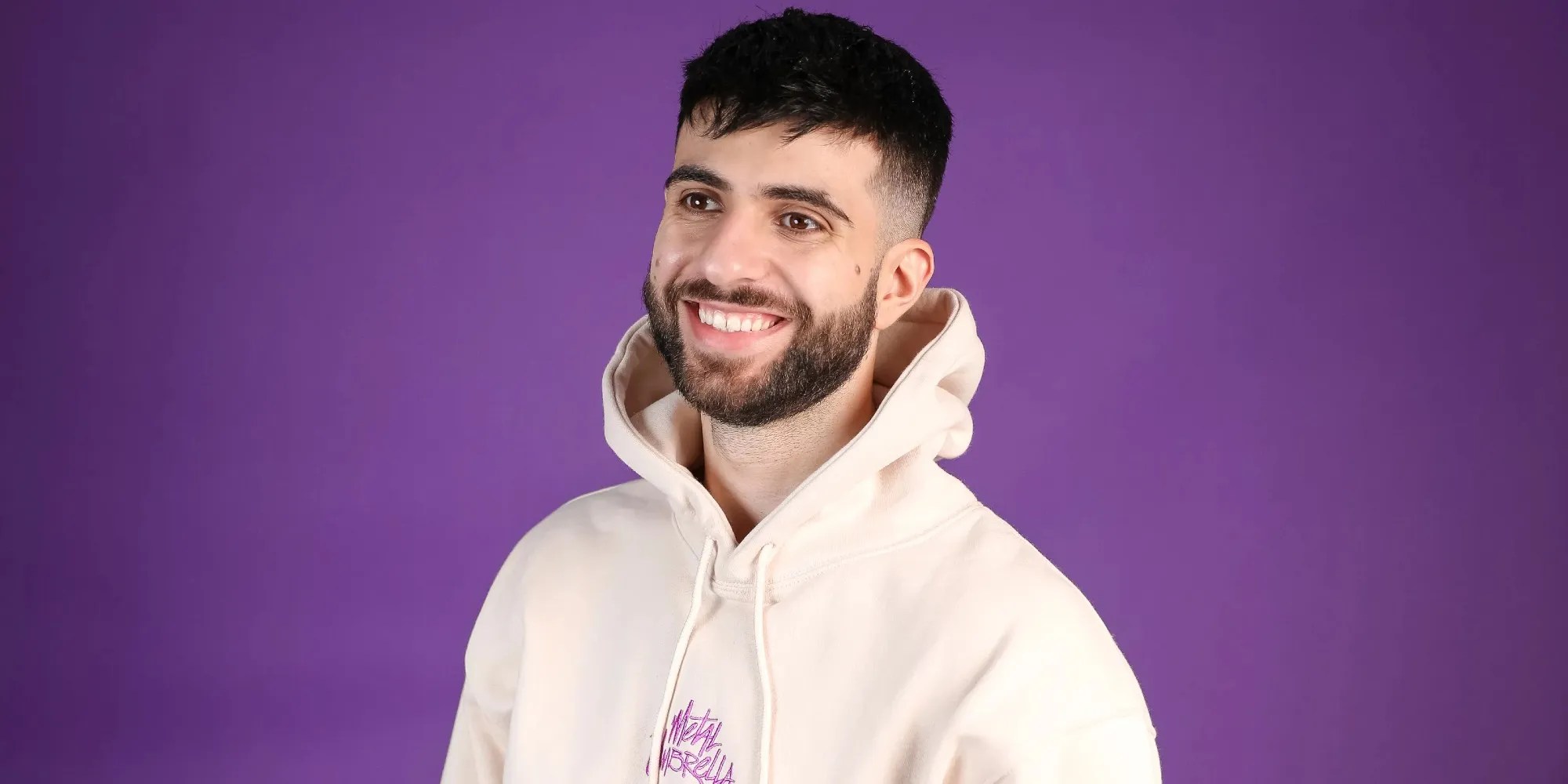 sypherpk smiling in front of a purple wall