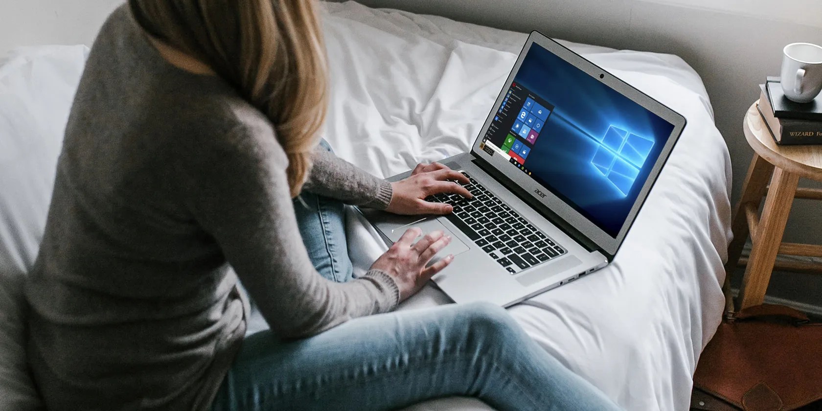 Woman using Windows 10 laptop on a bed
