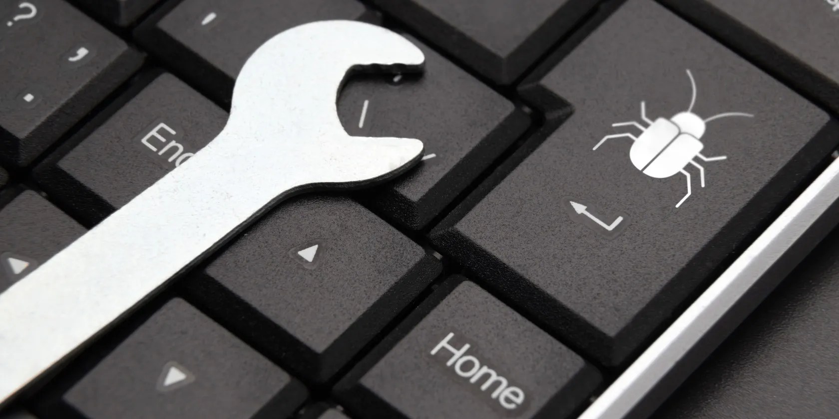 Wrench on a keyboard, with bug icon on the Enter key