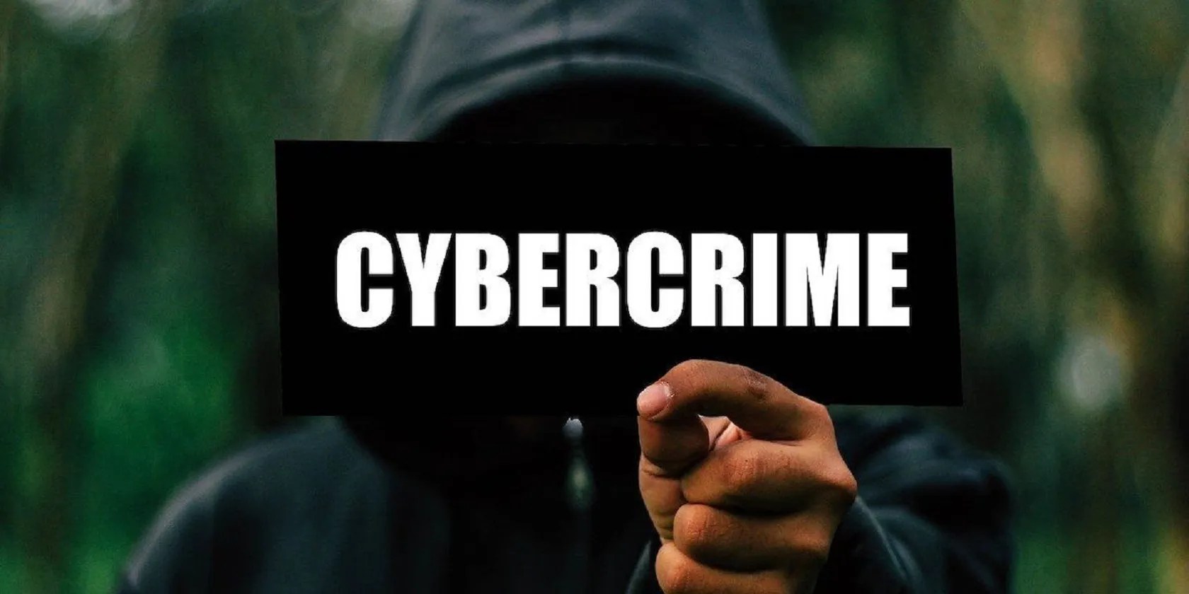Man holding cybercrime sign.