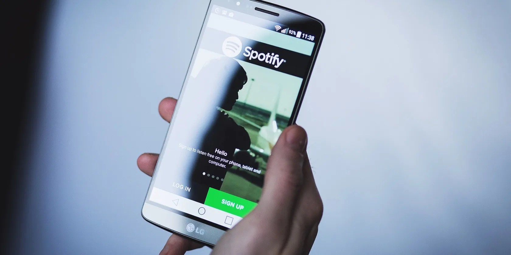 Hand holding a smart phone with Spotify logo
