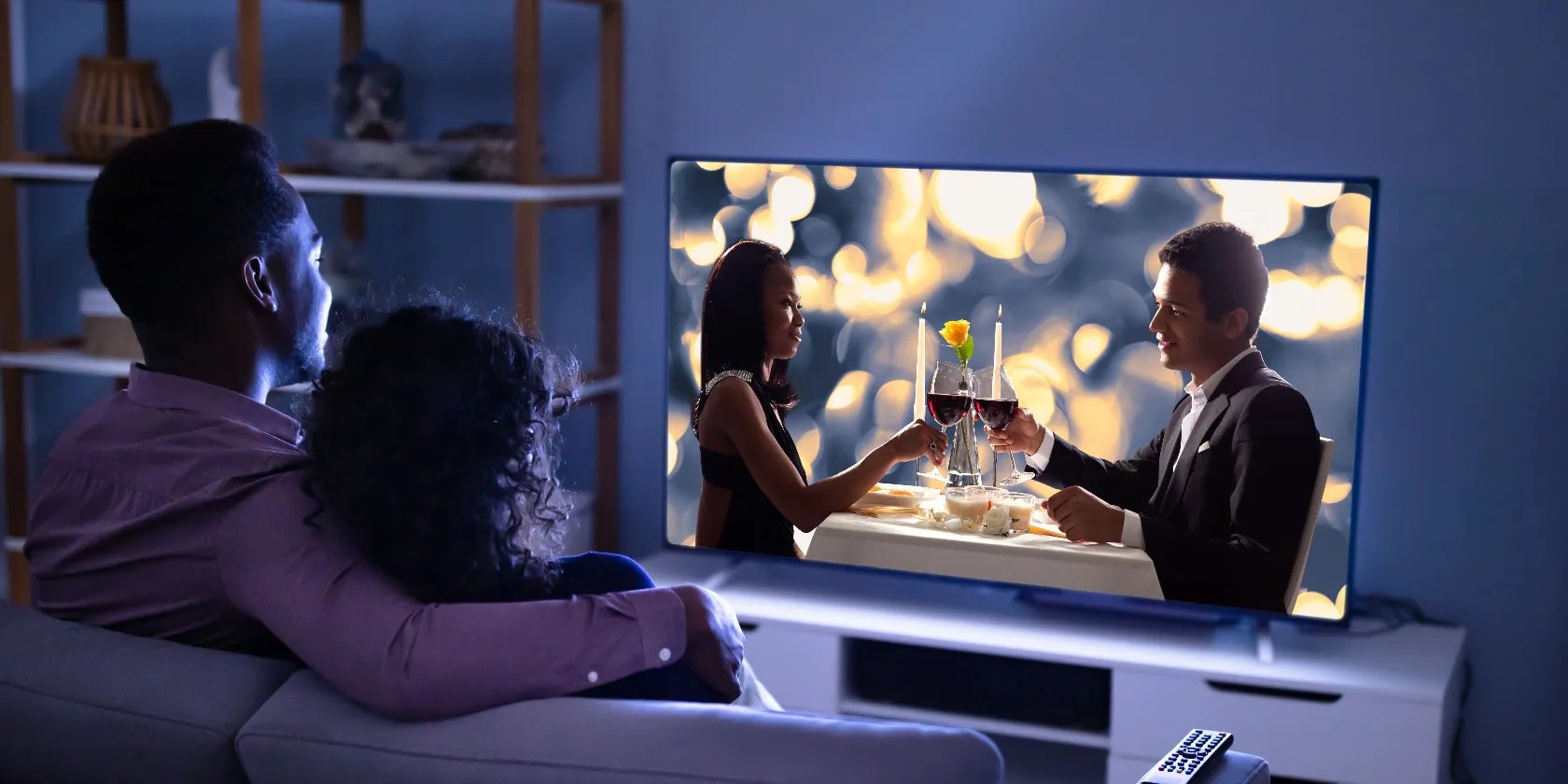 Affectionate Young Family Watching TV At Home