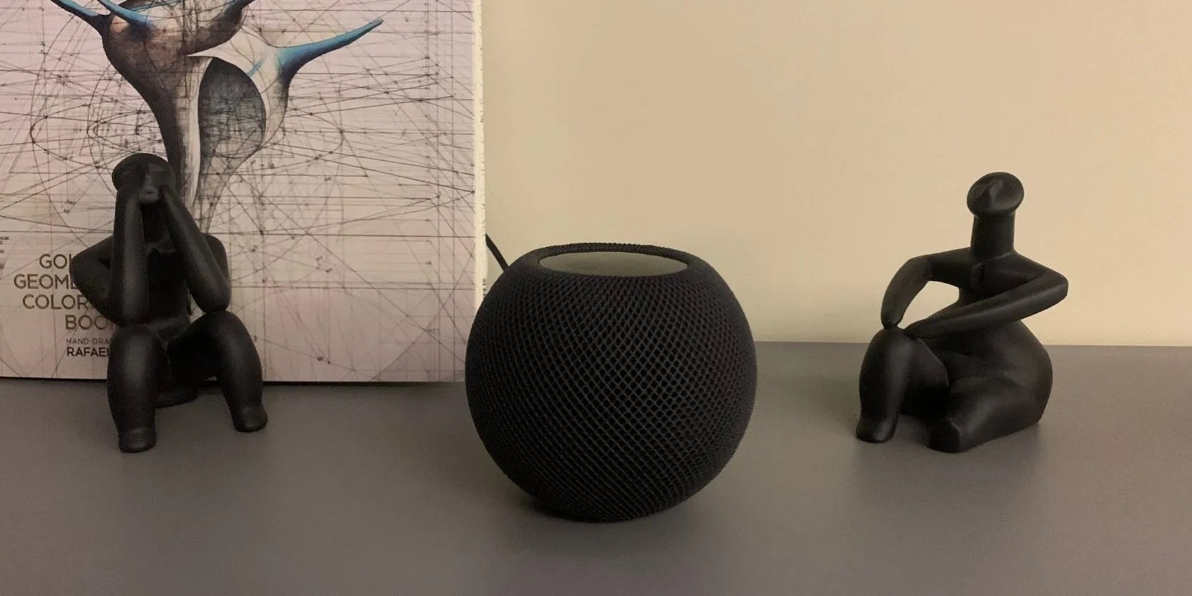 HomePod mini between two mini statues