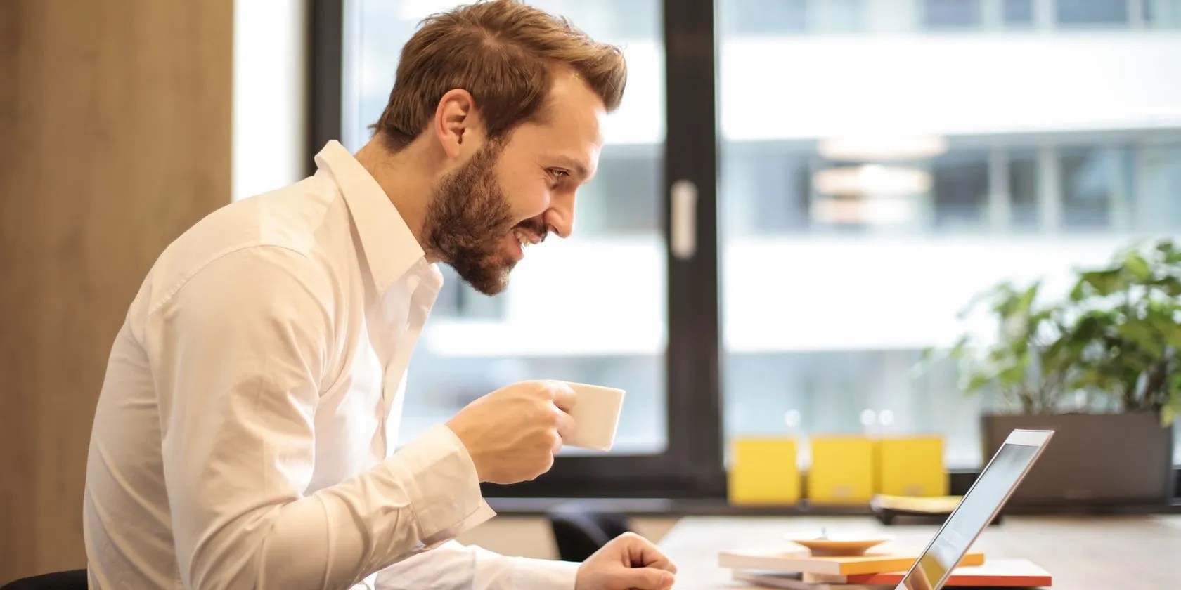 Man Having Coffee and Enjoying a Virtual Meeting on Laptop