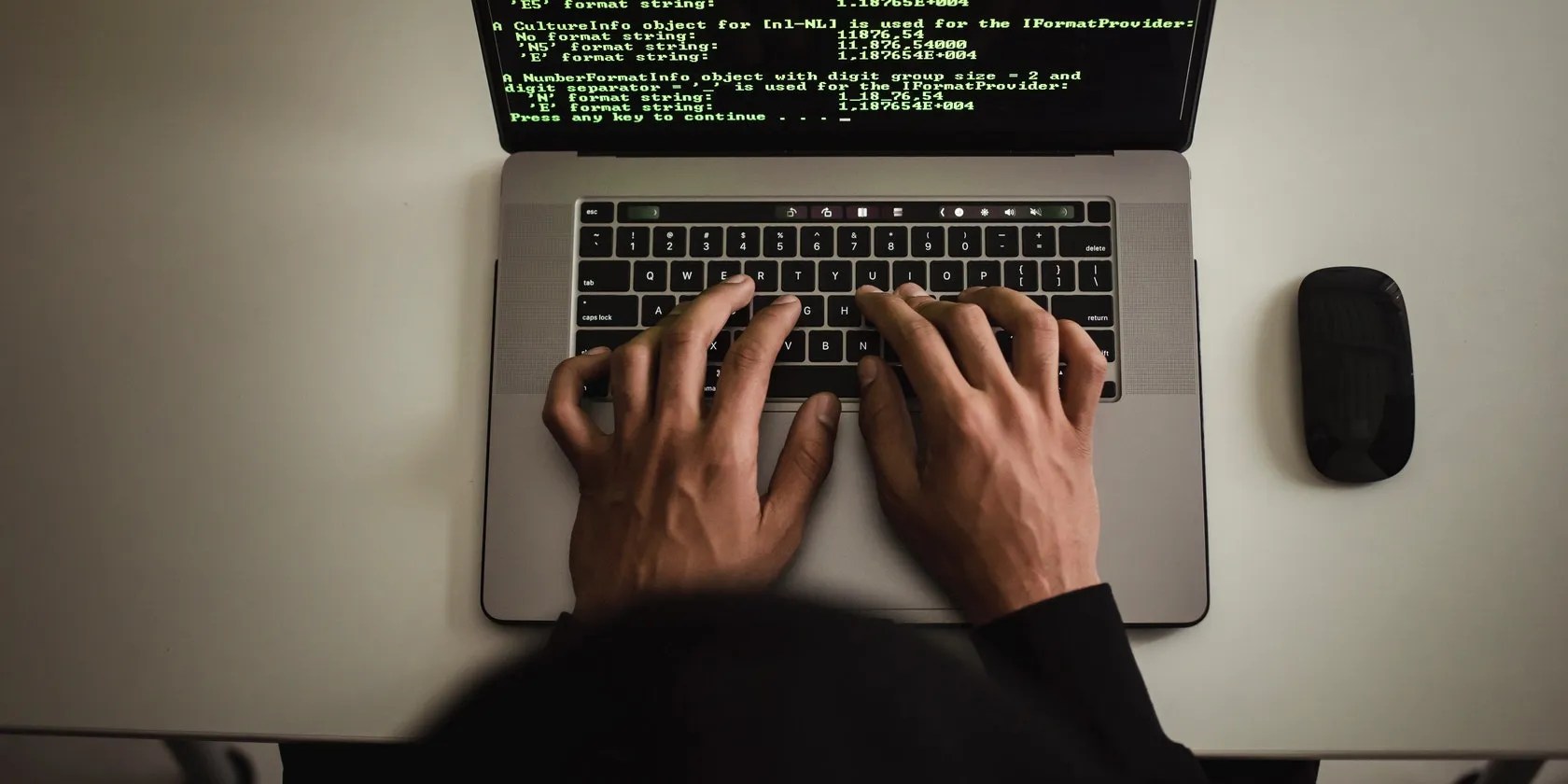 a person typing on laptop terminal