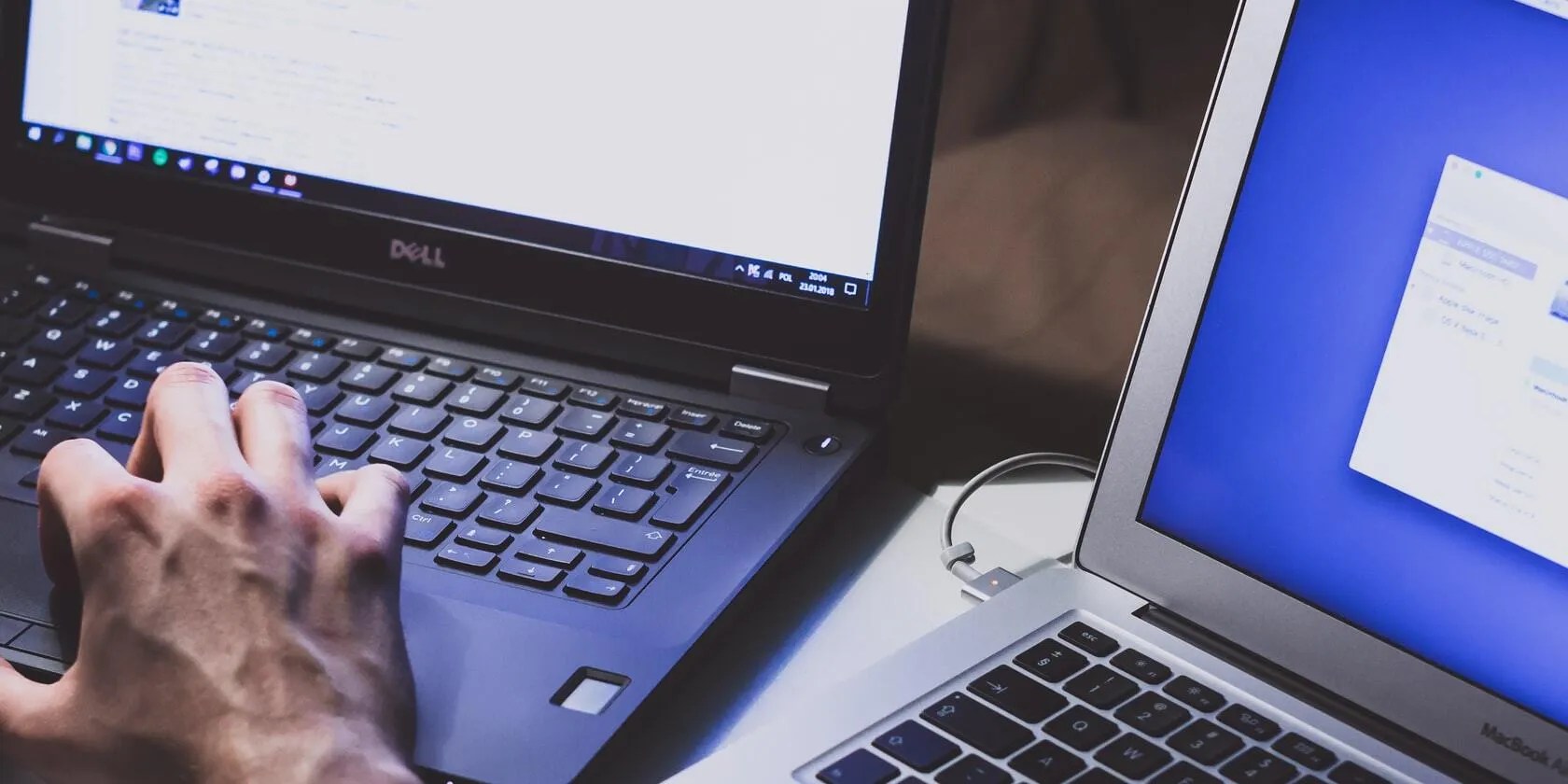 Image of a Macbook besides a Windows laptop