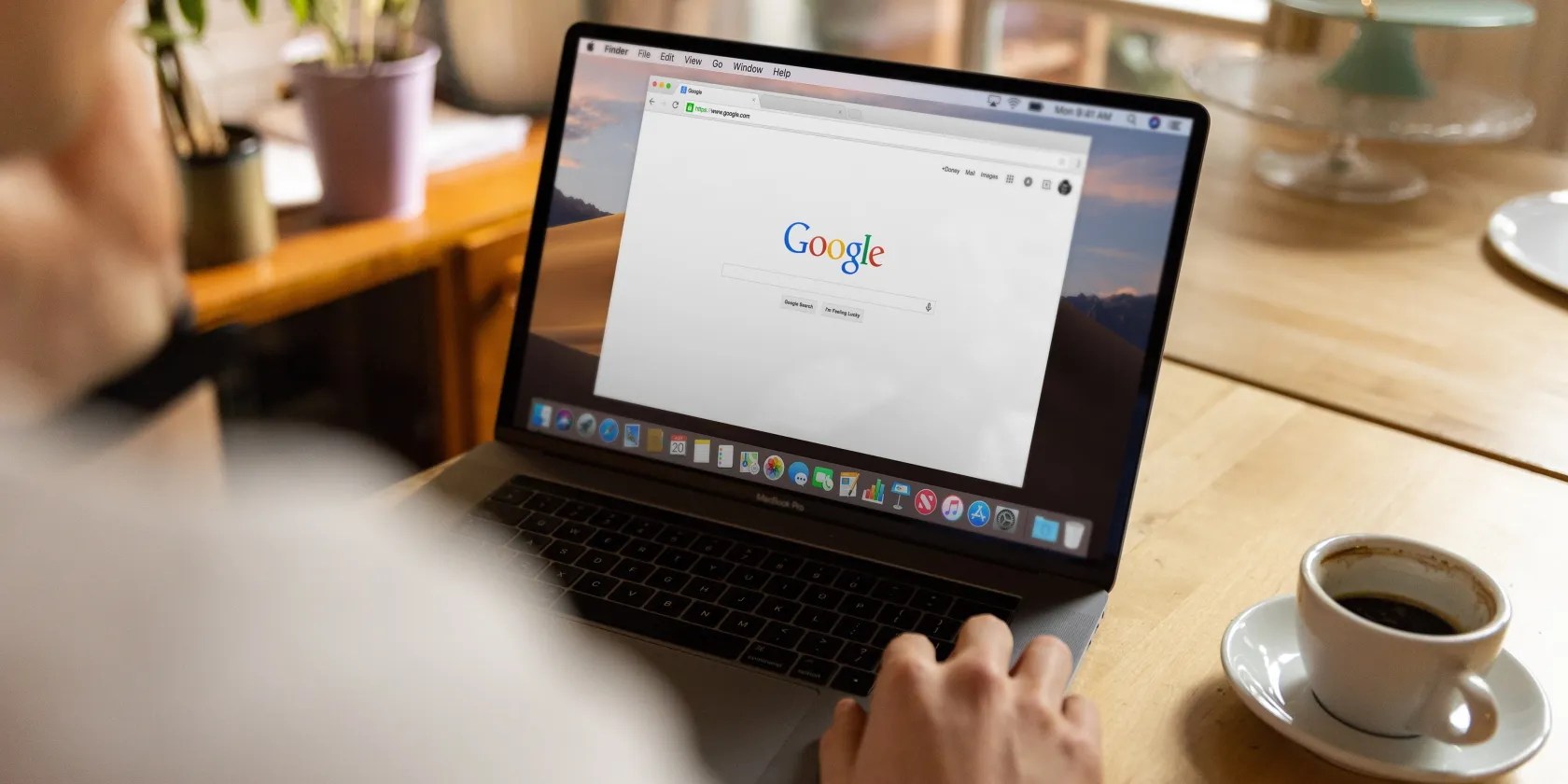 A person using a laptop on a wooden table