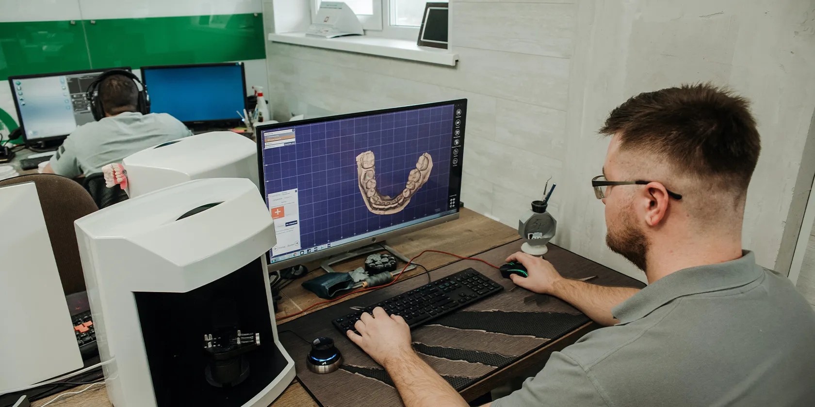 A man seated and designing a 3D model in his computer