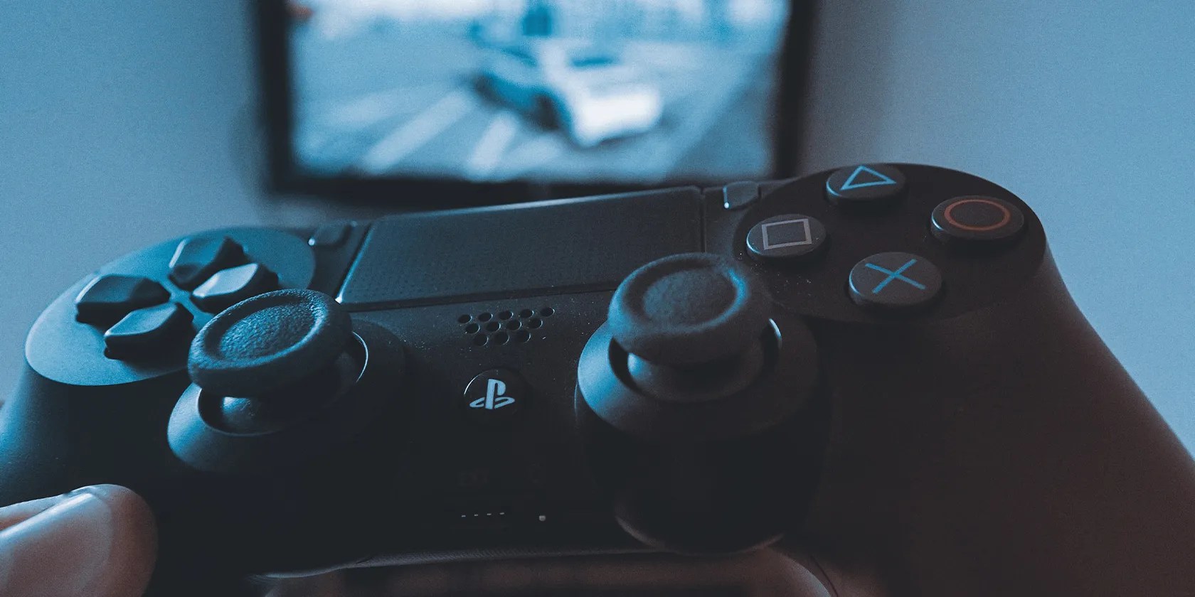 The left hand holding a ps4 controller