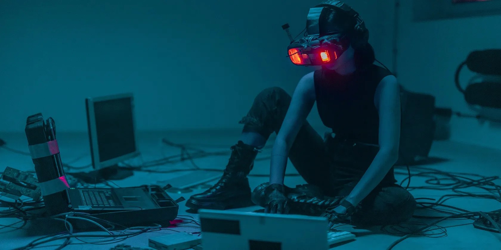 A seated lady using VR googles and several computers
