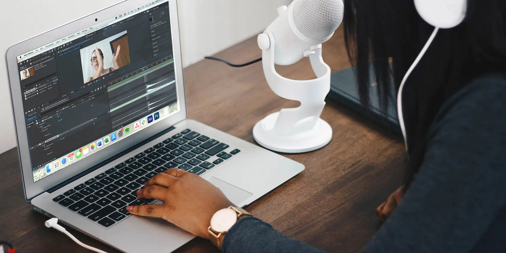 Woman working on Mac with white microphone.