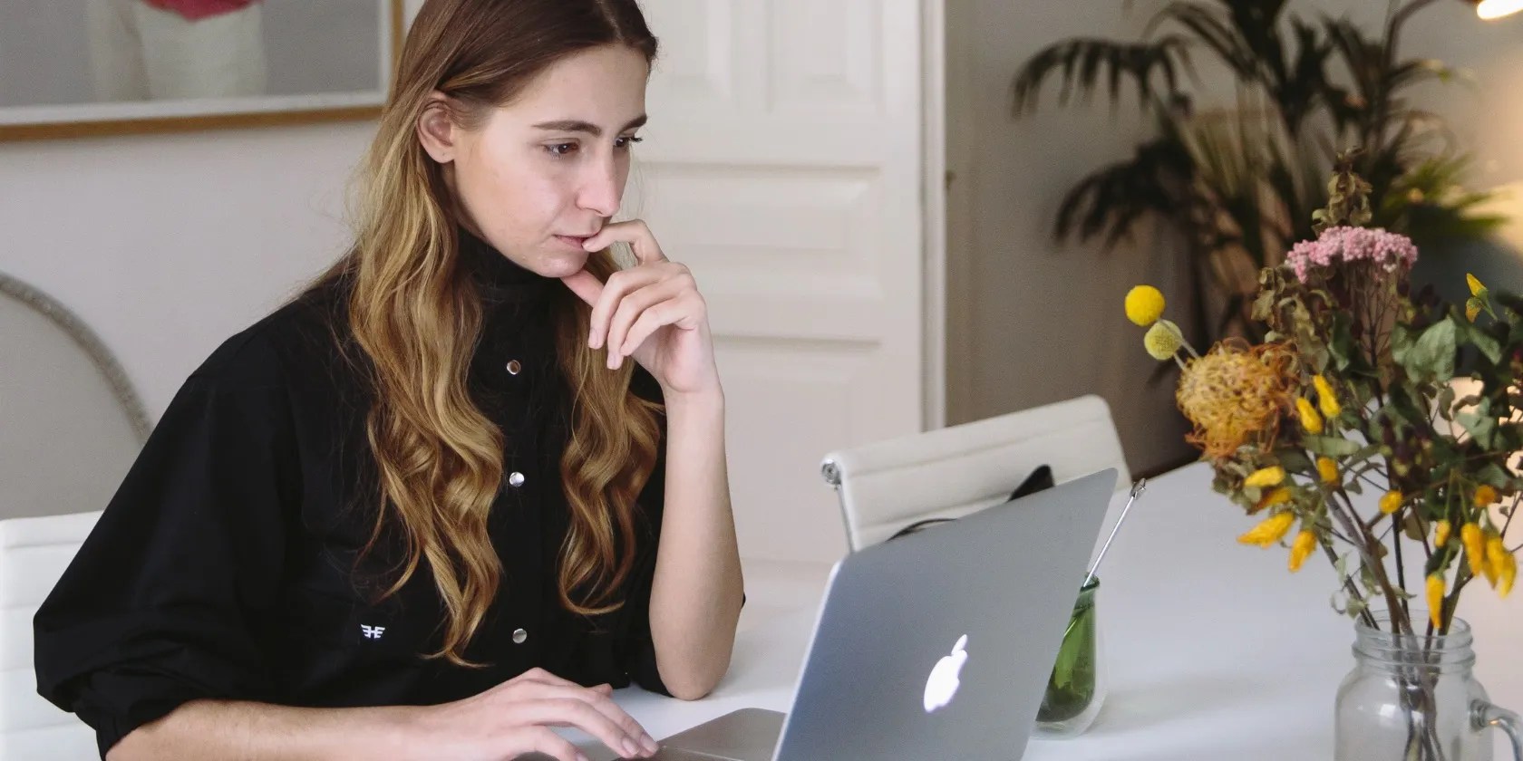 photo of a woman looking at a macbook