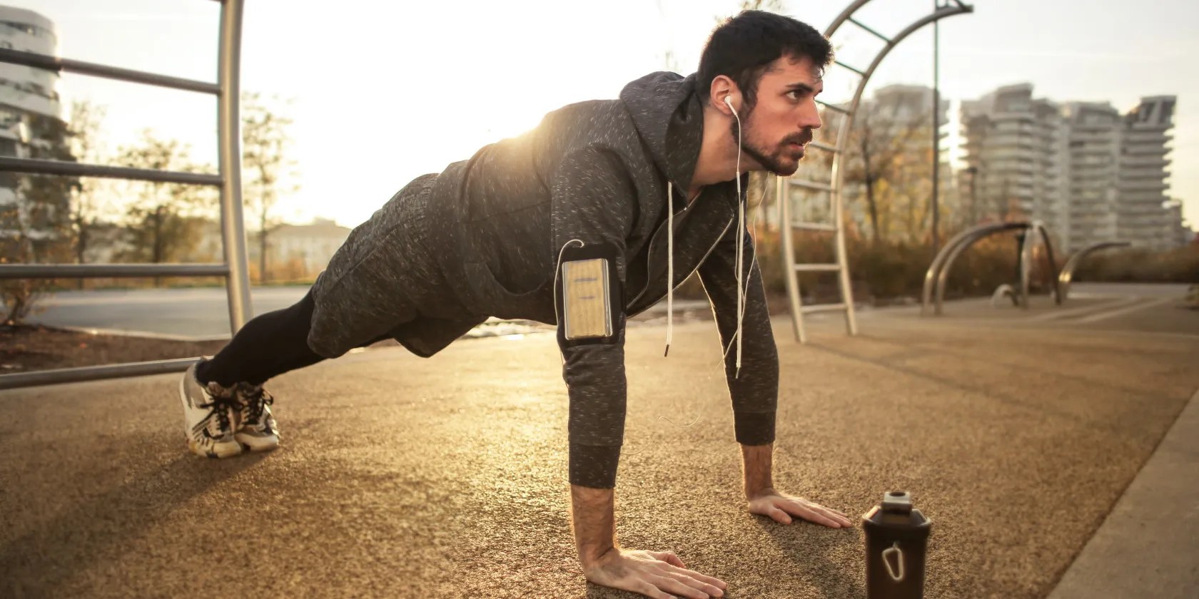 man wearing workout clothes exercising outdoors at sunset