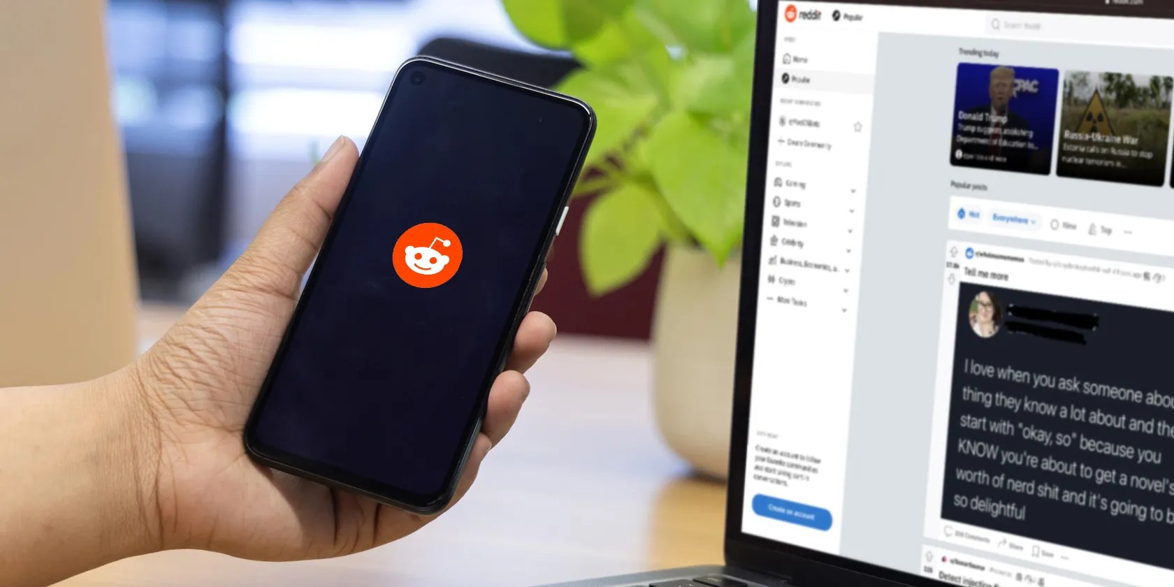 Reddit logo on a smartphone screen next to laptop