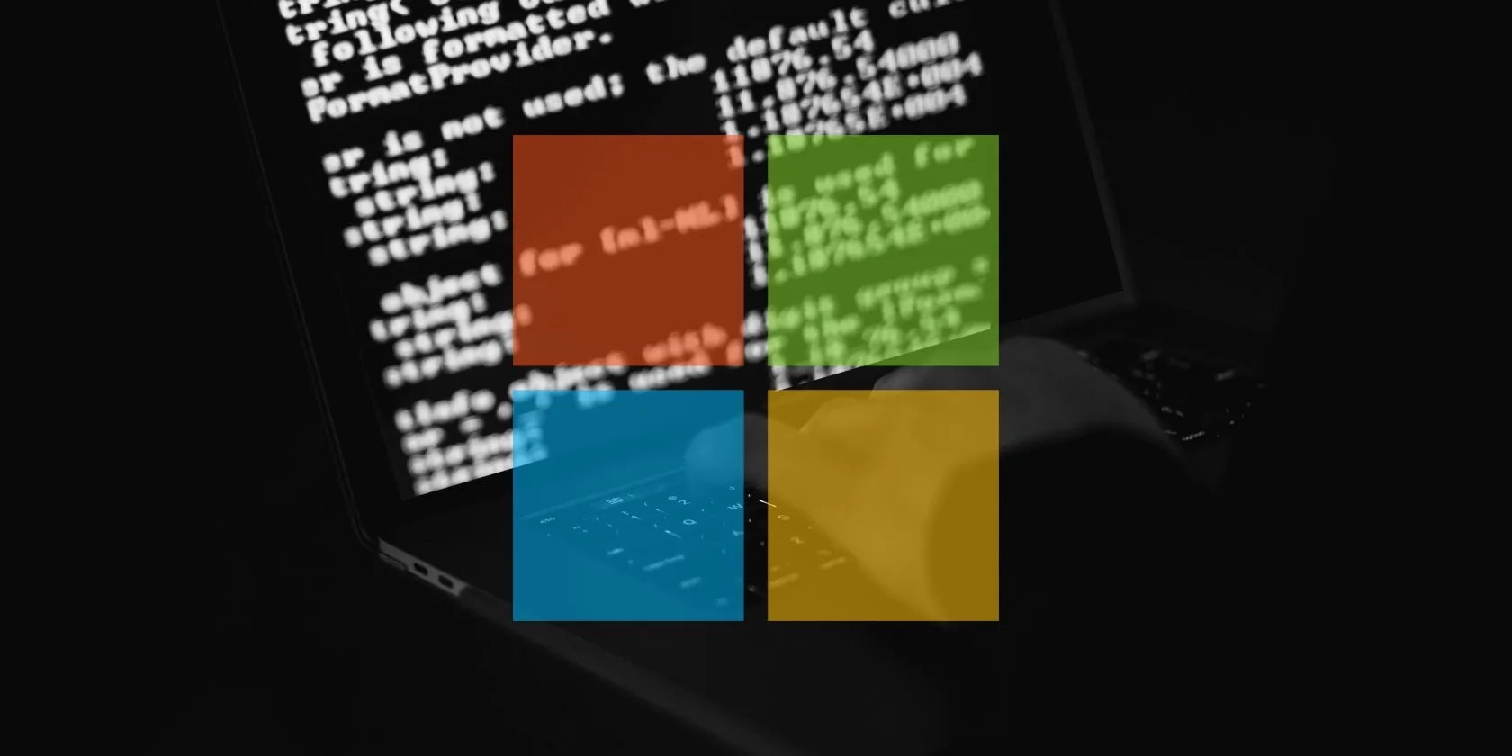 person coding on laptop behind windows logo