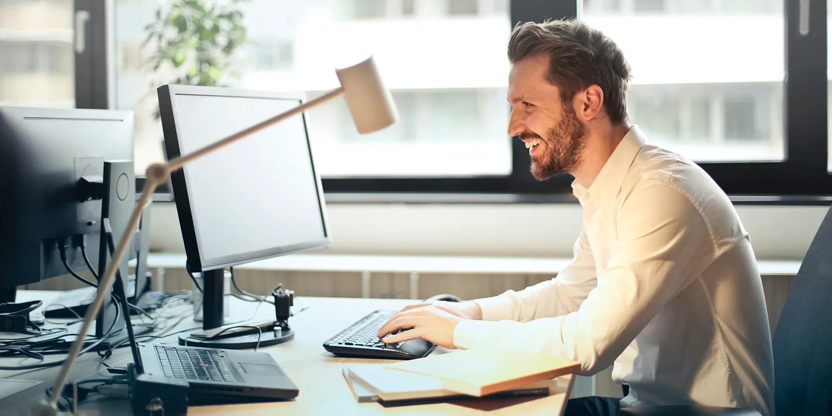Man working on computer and smiling