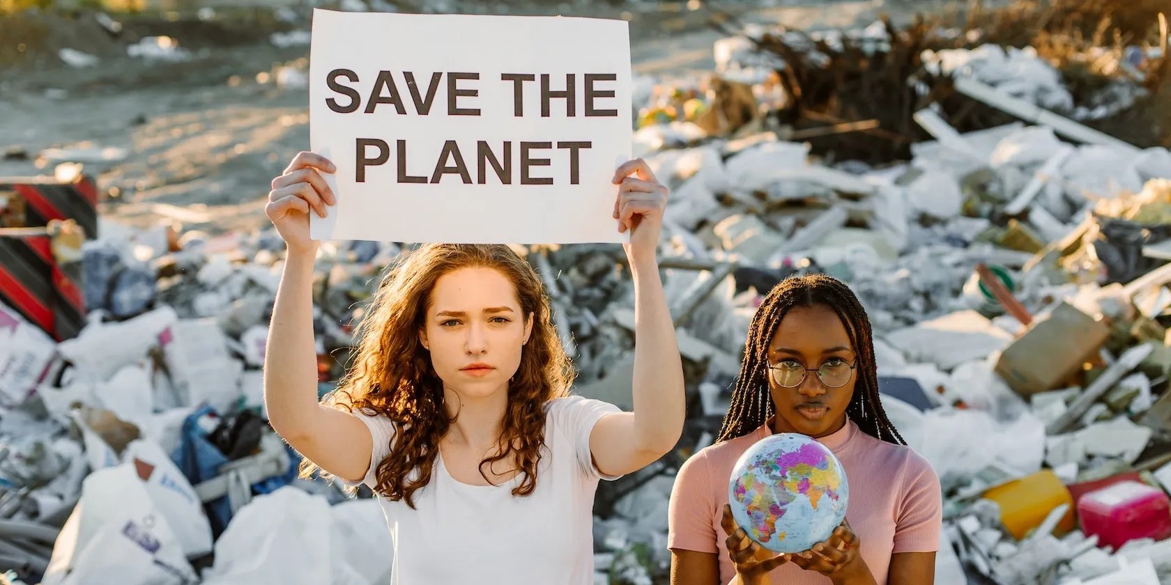 Two women protesting in front of a waste dump