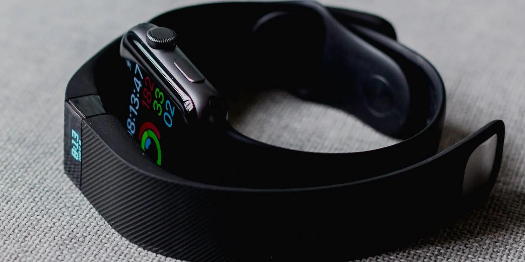 image of a Fitbit surrounding an Apple Watch