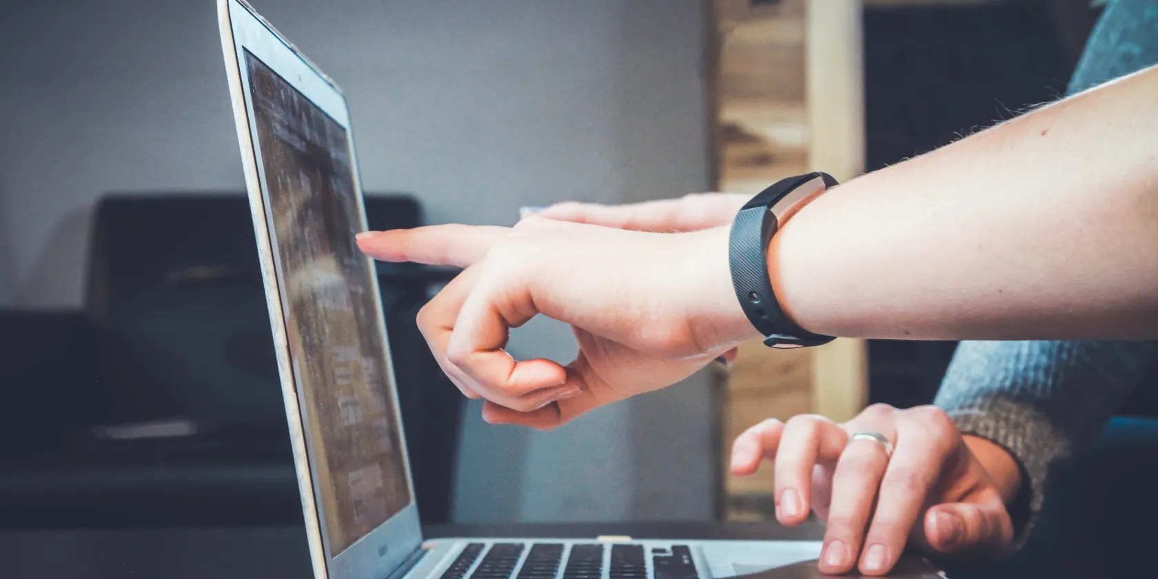 A laptop user discusses something with another