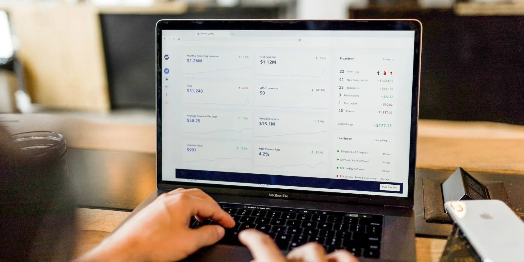 Looking at a laptop screen, hands in the foreground are typing on the keyboard