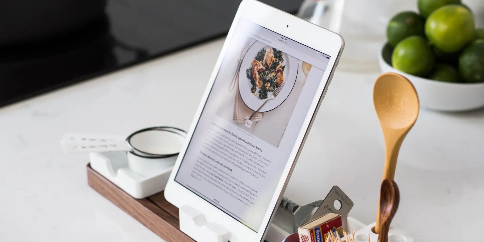 Tablet on a kitchen counter with a wooden spoon