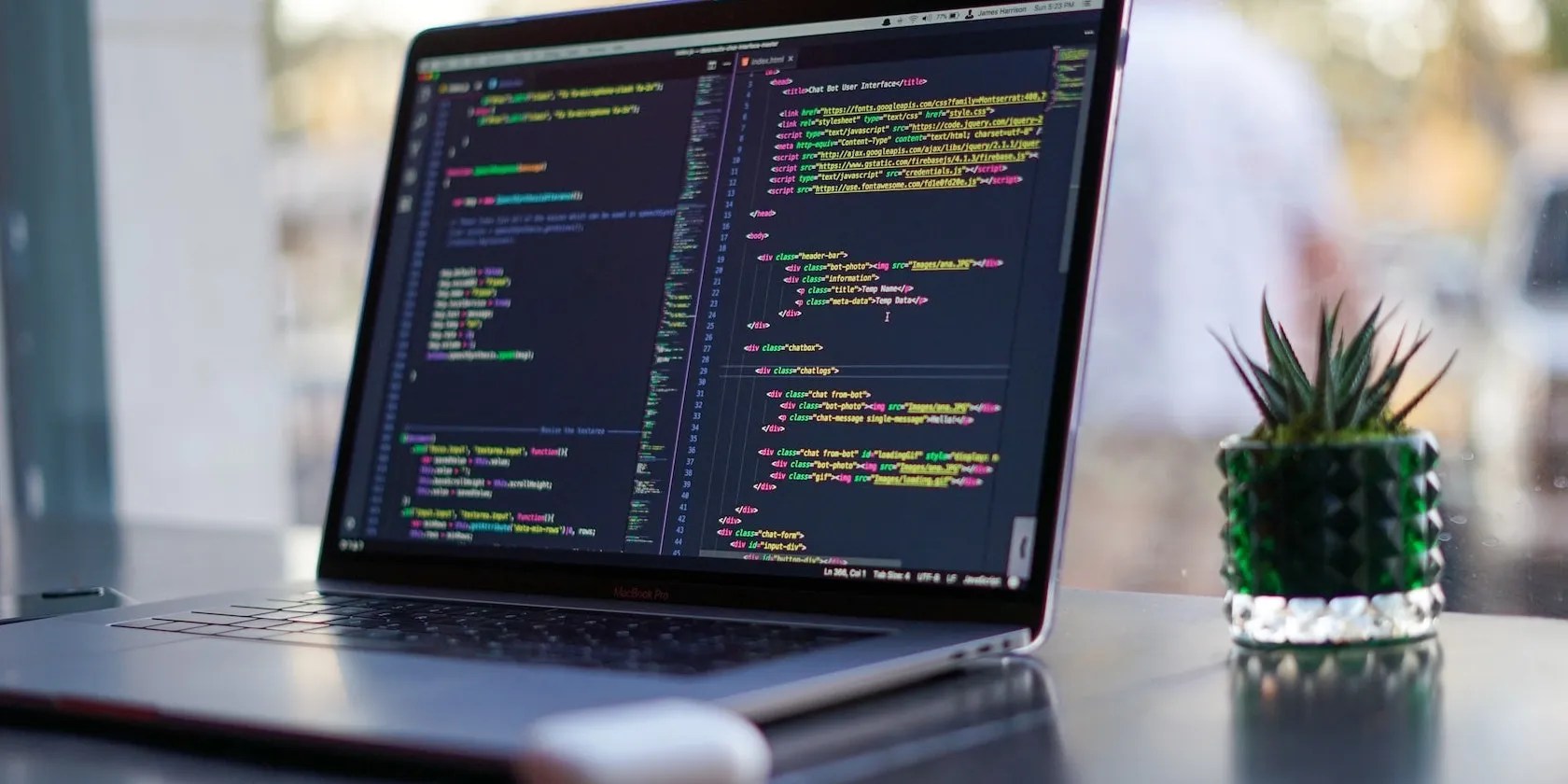 Laptop on a desk showing a code editor with a dark background.