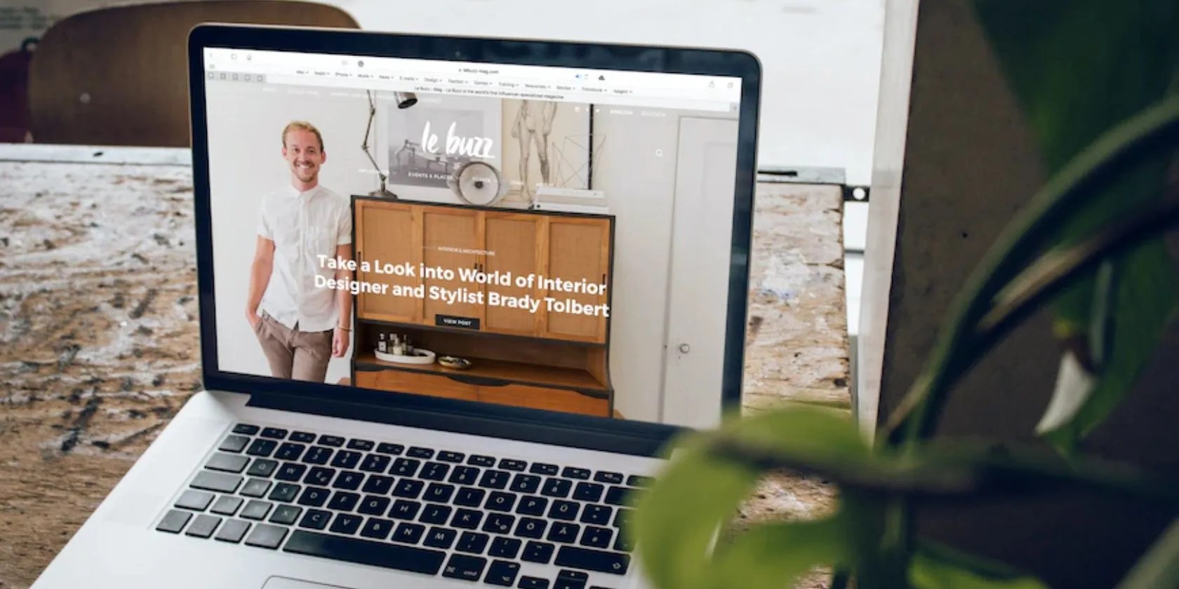 An open laptop displaying a web site about an interior designer