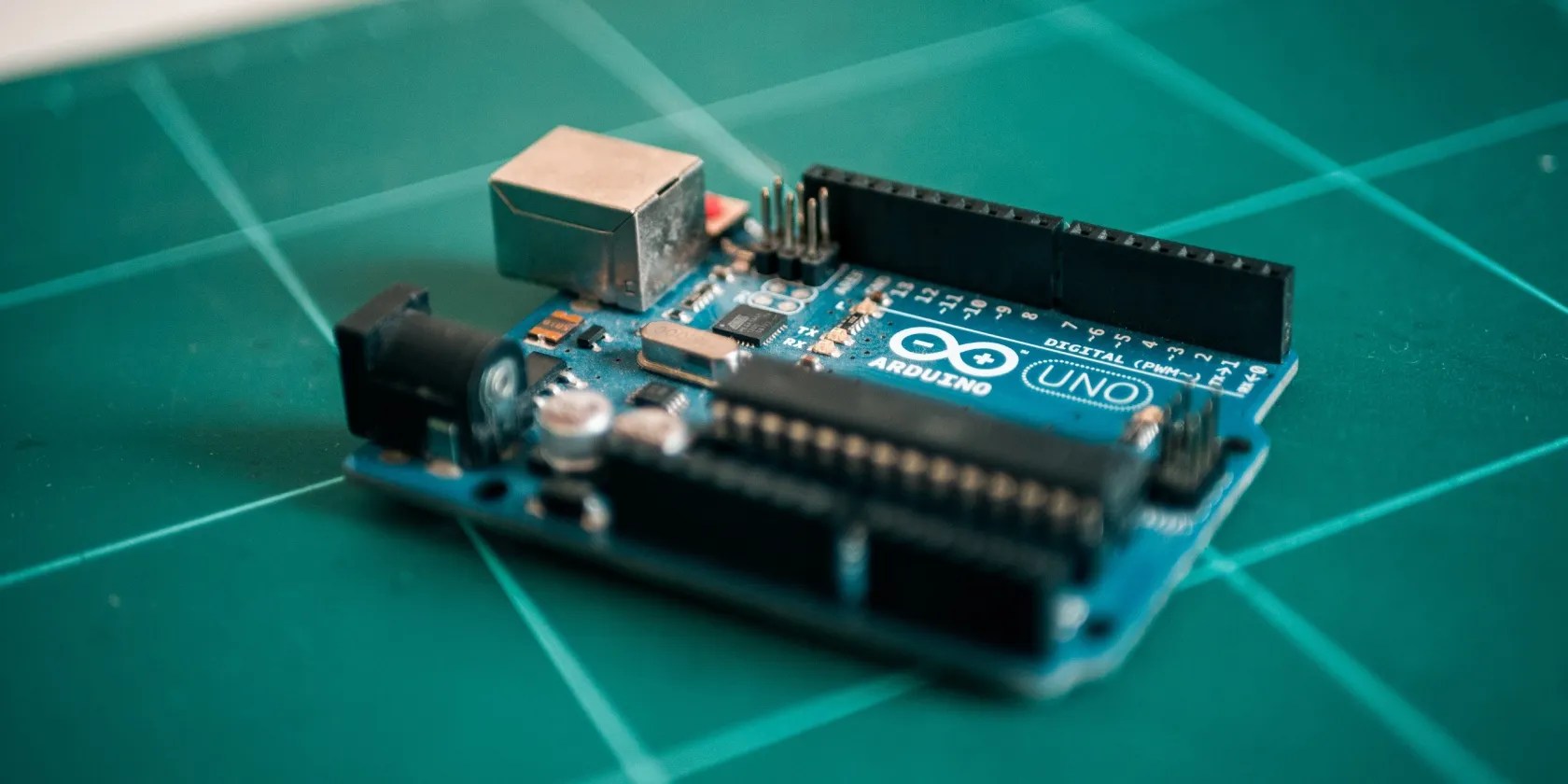 An Arduino Board on a teal checkered mat