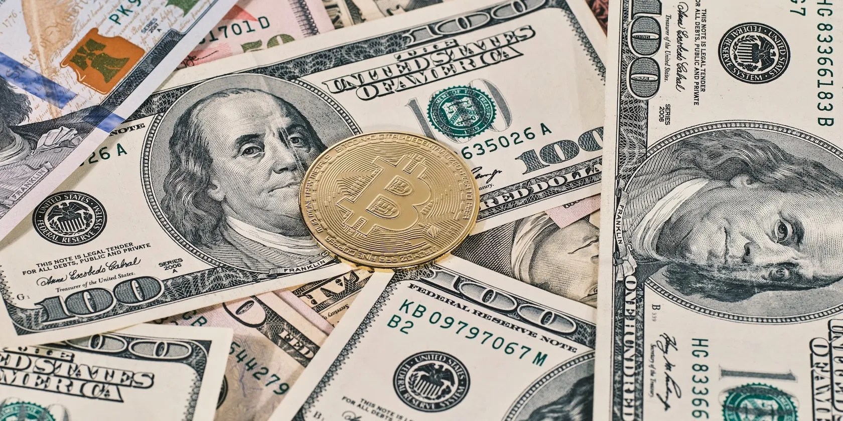 a picture of dollar notes and bitcoin token