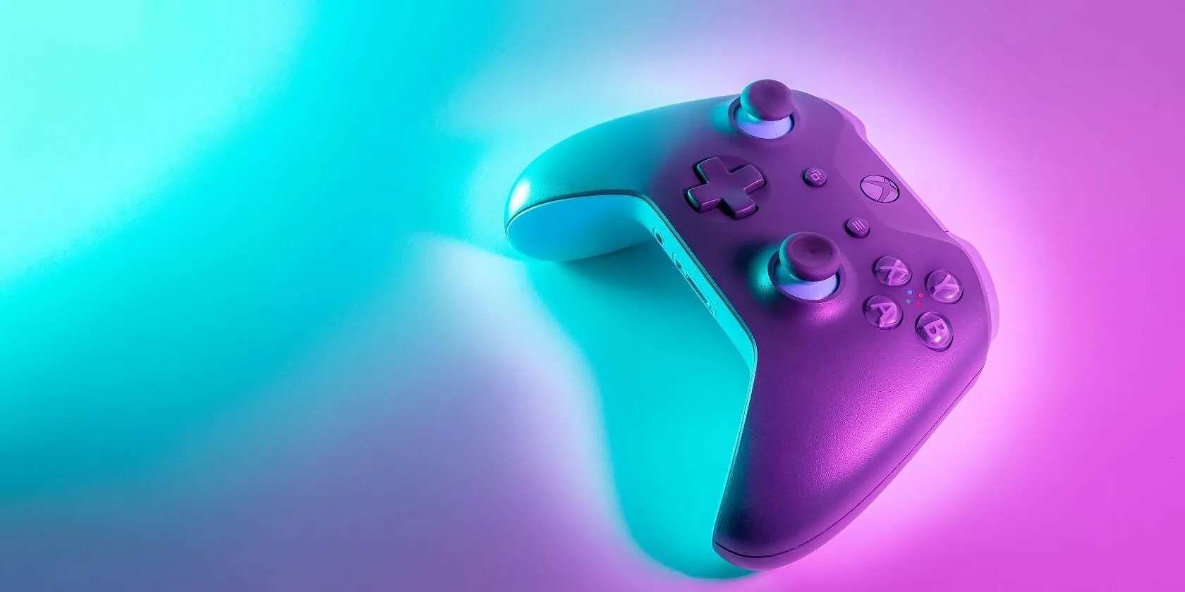 A picture of a purple and white coloured Xbox controller with a neon blue and purple light silhouetting it